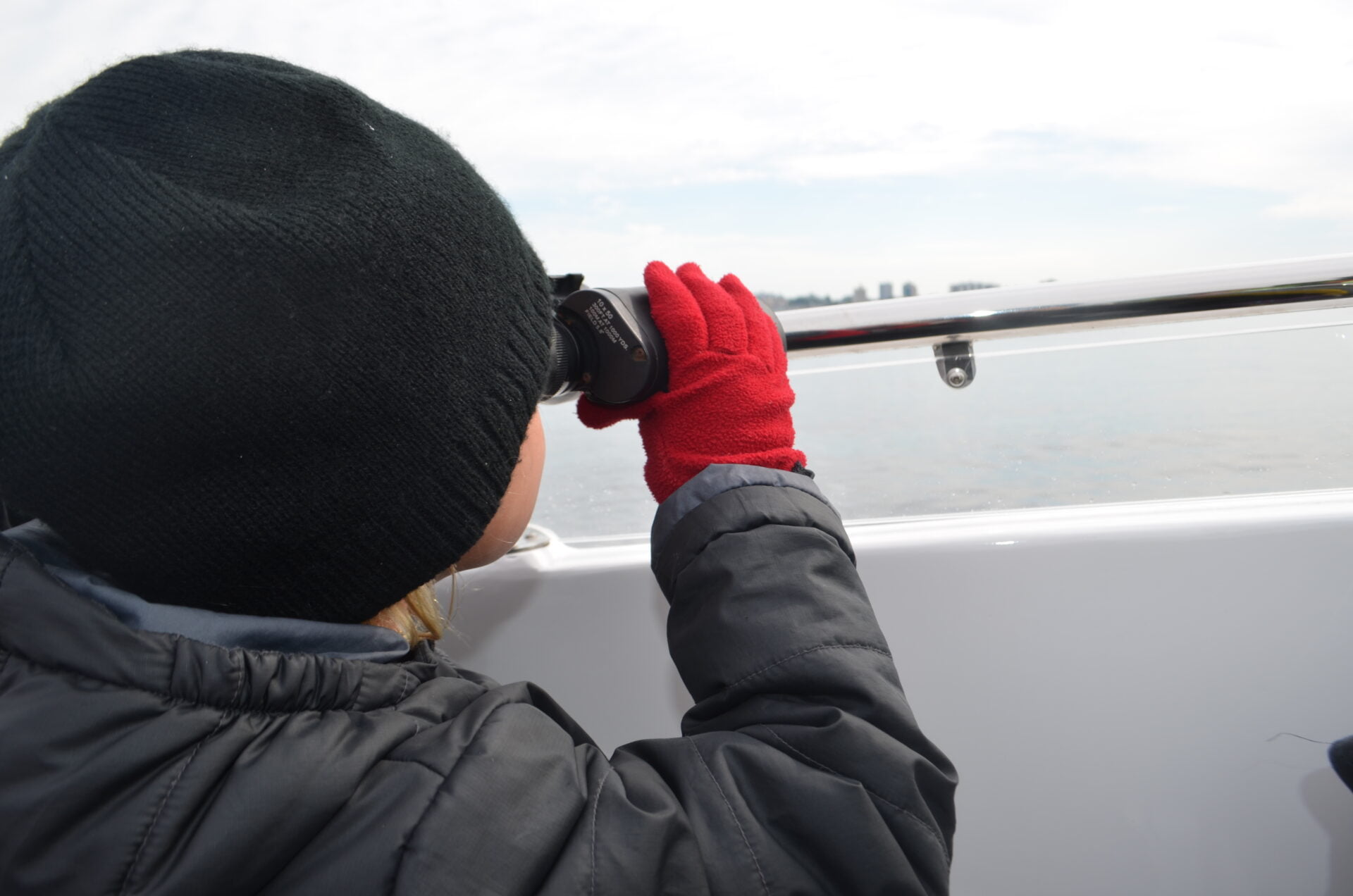 little girl using binoculars to whale watch