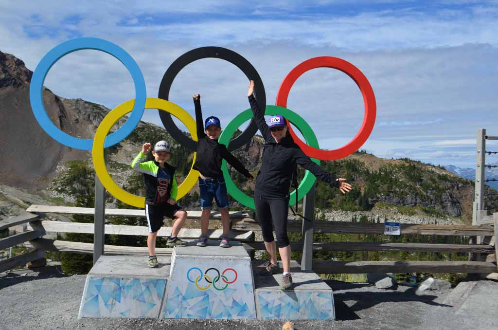 Family posing in front of the olympic rings