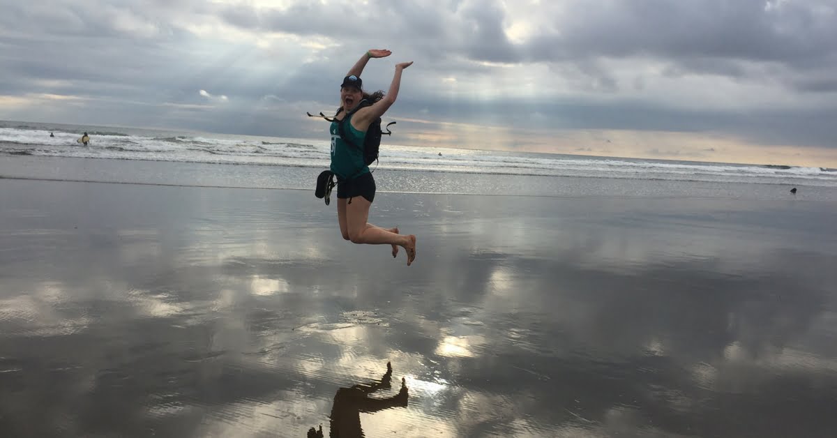 woman jumping on the beach at the run like a girl adventure retreat in costa rica