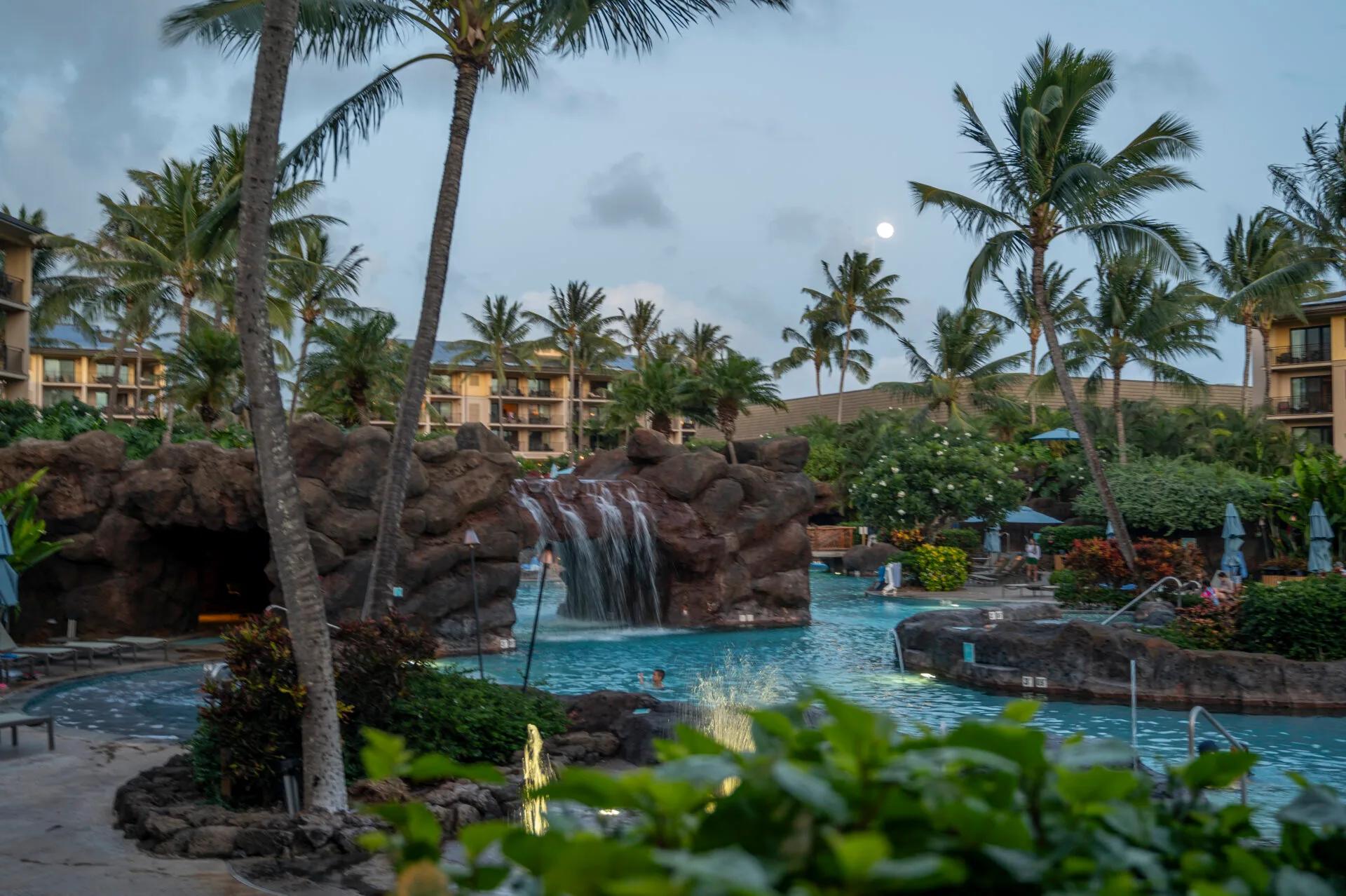 dusk photo of the large pool at koloa landing resort