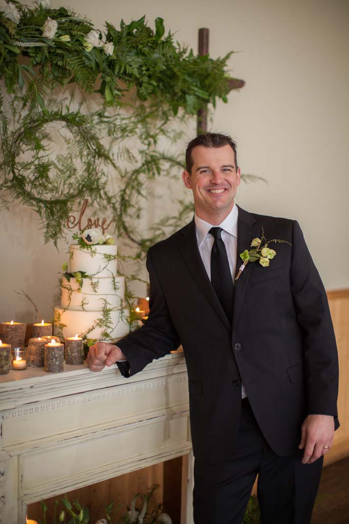 groom-standing-next-to-cake