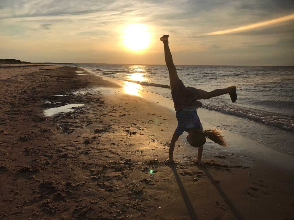 girl-doing-cartwheel-on-beach-in-PEI-national-park