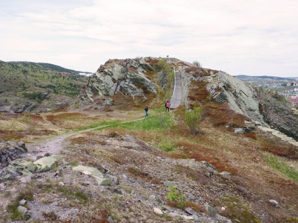 two hikers walking towards the stairs that lead to the top of Gibbet Hill at the Signal Hill National Historic Site