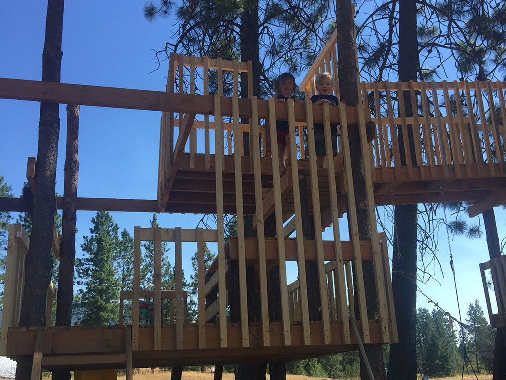 two kids at the top of a Home Made Tree House at keenan family farms