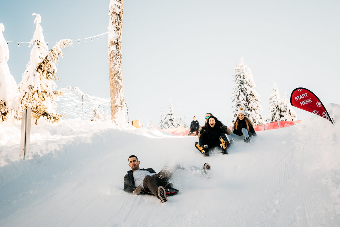 People sledding on Grouse Mountain for Vancouver day trips for families