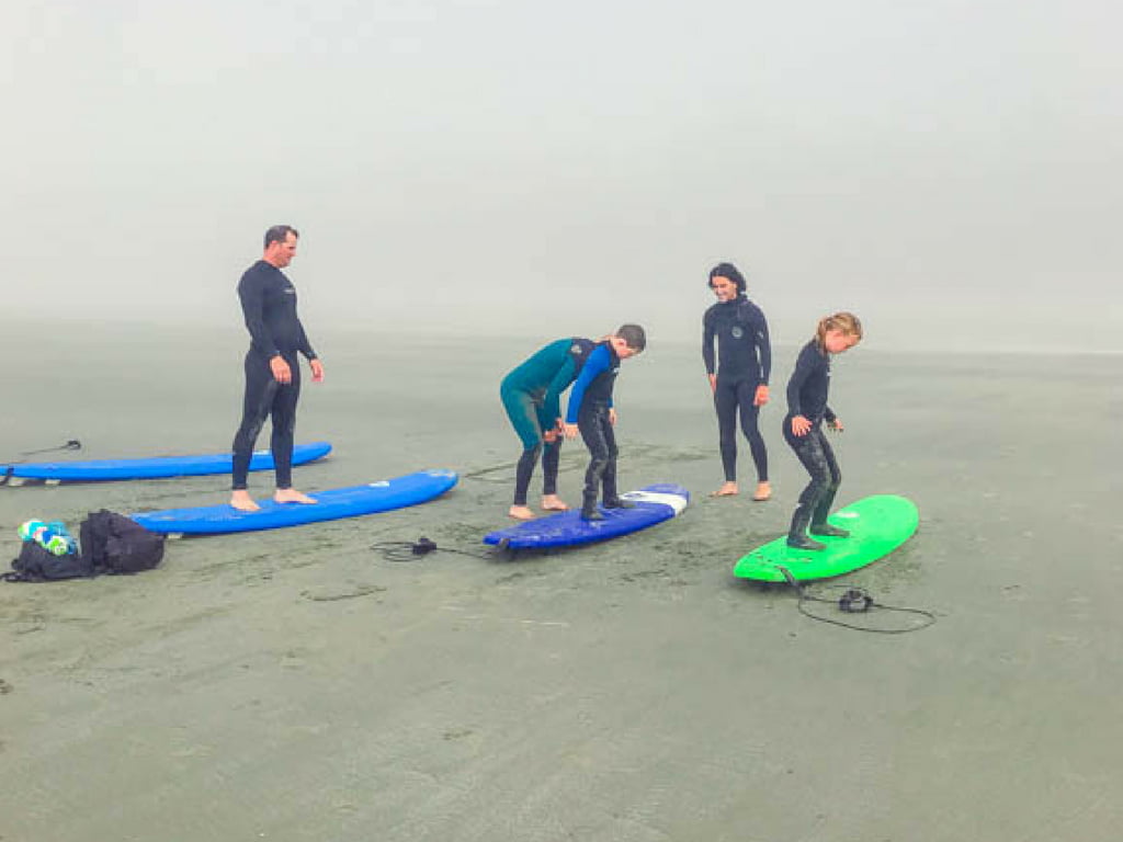 Learning to surf on the beach for our Tofino Surf School review