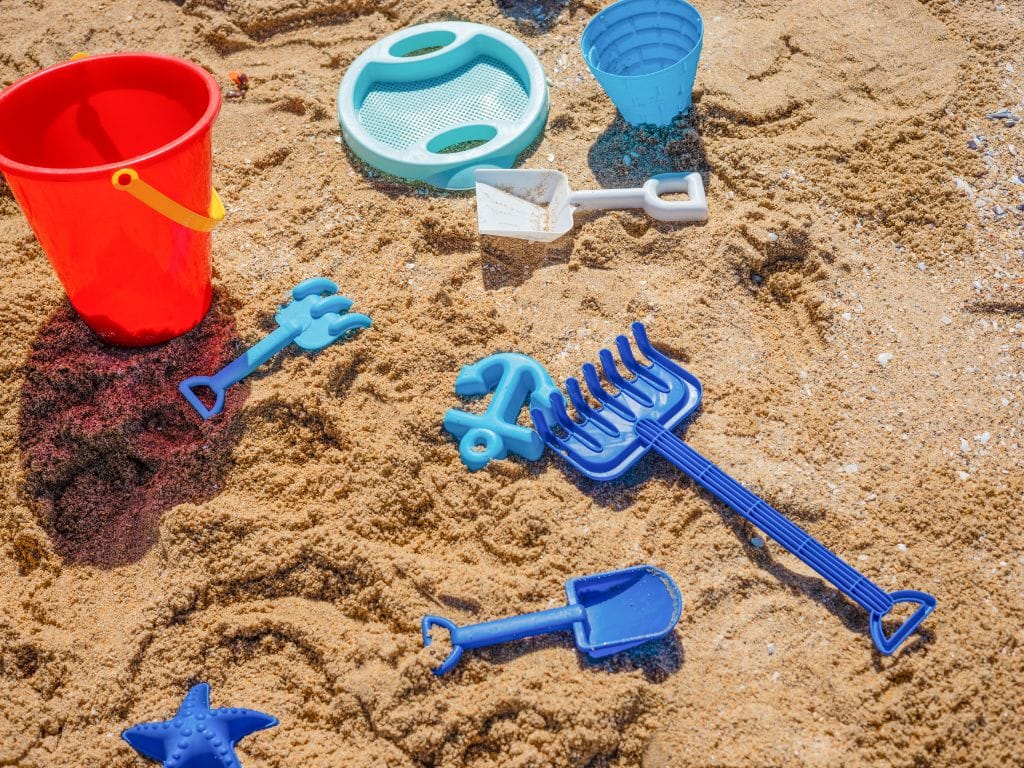 kids sand toys, buckets and shovels, sitting in the sand