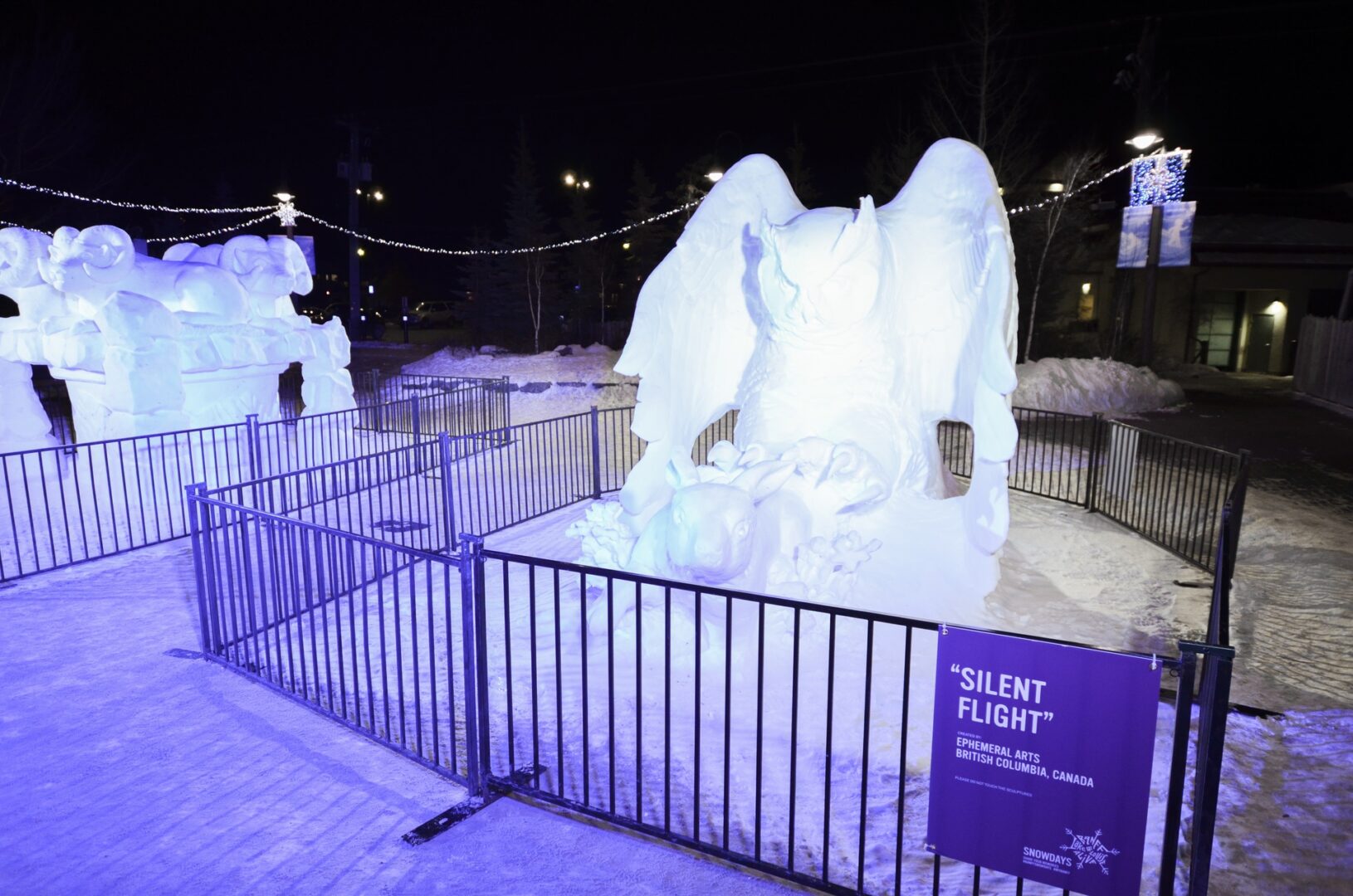 Snow sculpture of owl grabbing a rabbit at Banff SnowDays Festival
