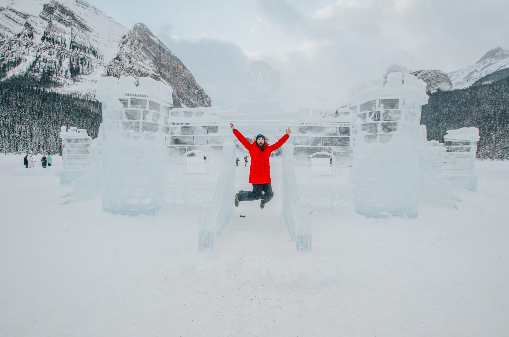 Jami Savage jumping in front of ice castle at the Lake Louise Ice Magic Festival 