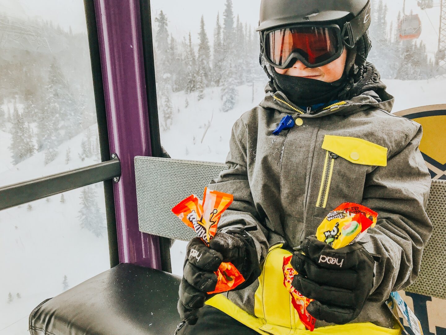 Boy with snacks on gondola at Sunshine Village Ski & Snowboard Resort Banff