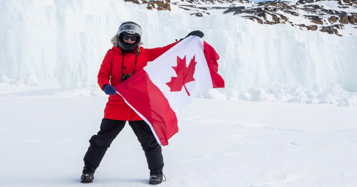 woman-holding-canadian-flag-on-ice-in-nunavut