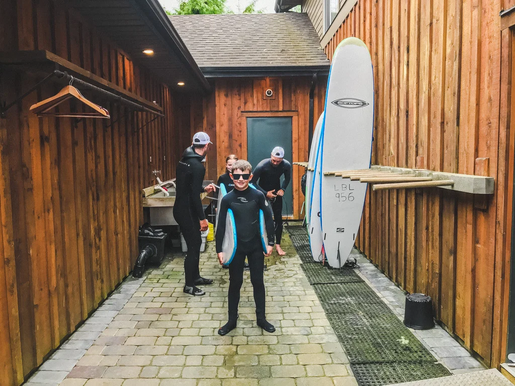 boy-bringing-in-surf-board-after-surfing