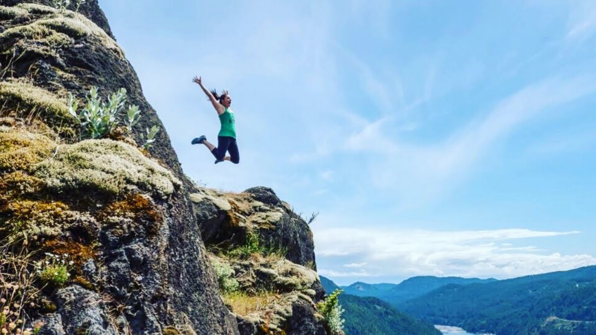 Jami Savage jumping off a mountain