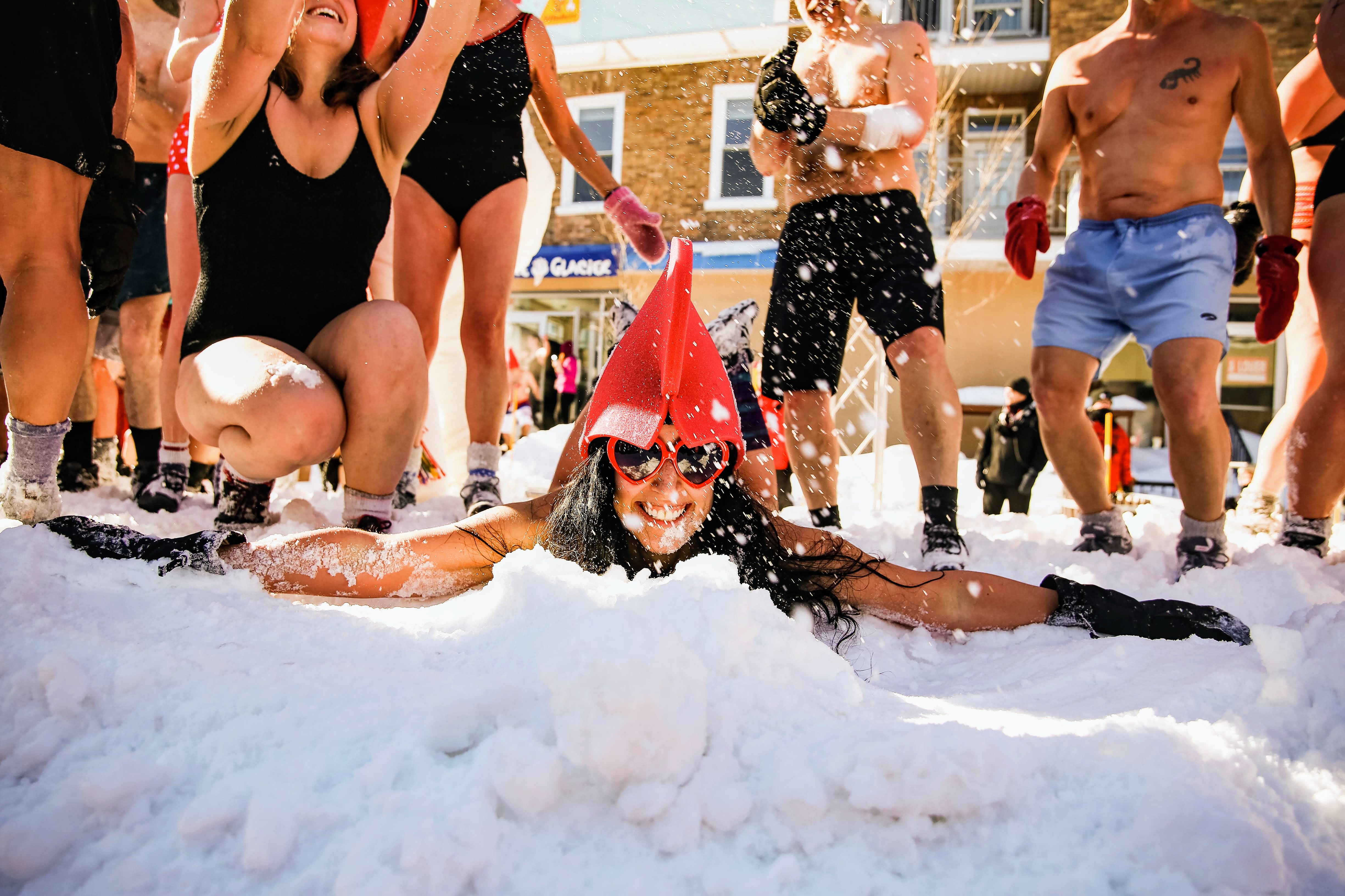 woman lying down in the snow in a swimsuit during the snow bath at Carnaval De Quebec