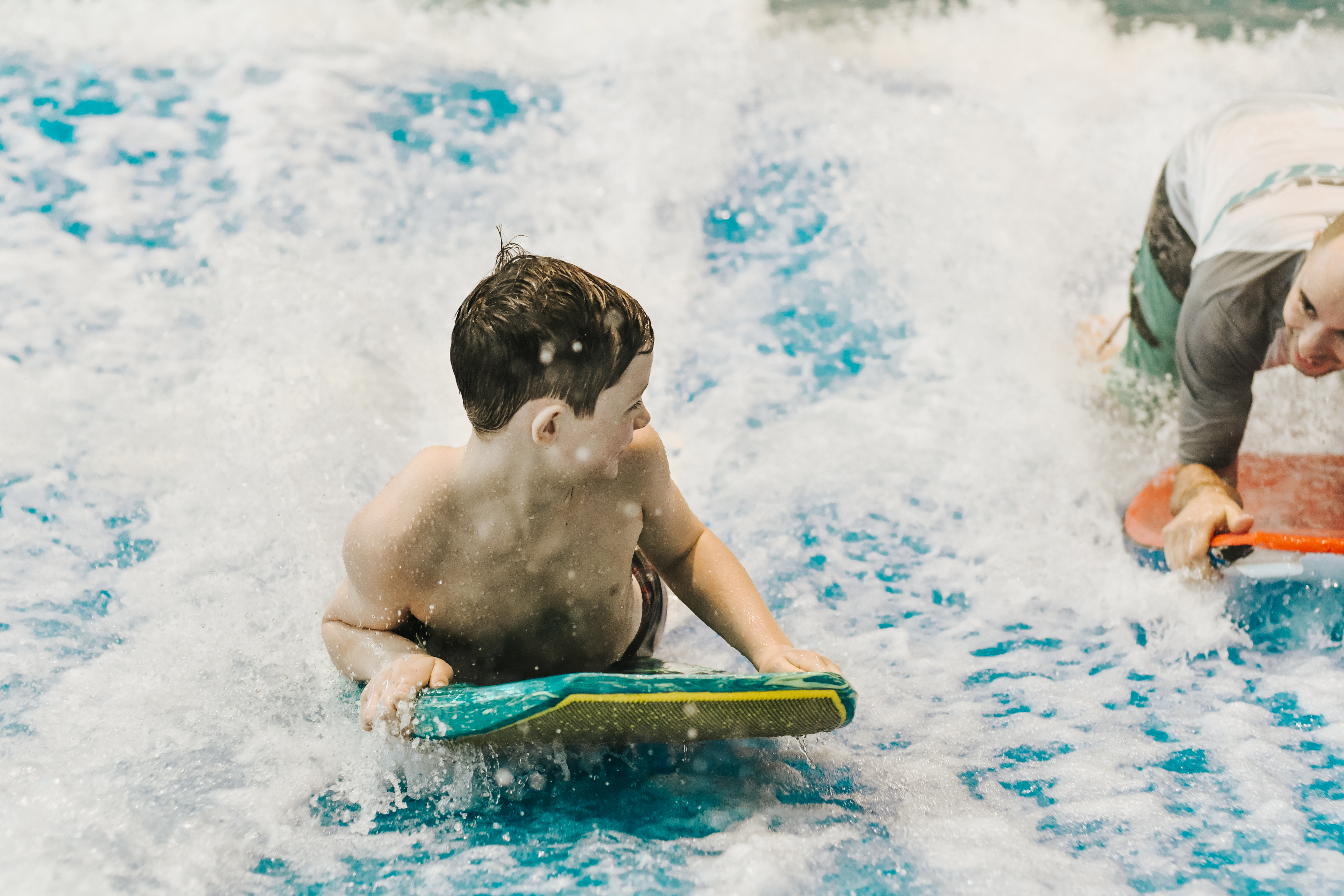 boy on surf board getting coached by an instructor at laval indoor surfing