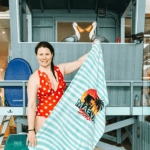 jami savage on the sidelines holding a maeva surf towel in front of the gift shop