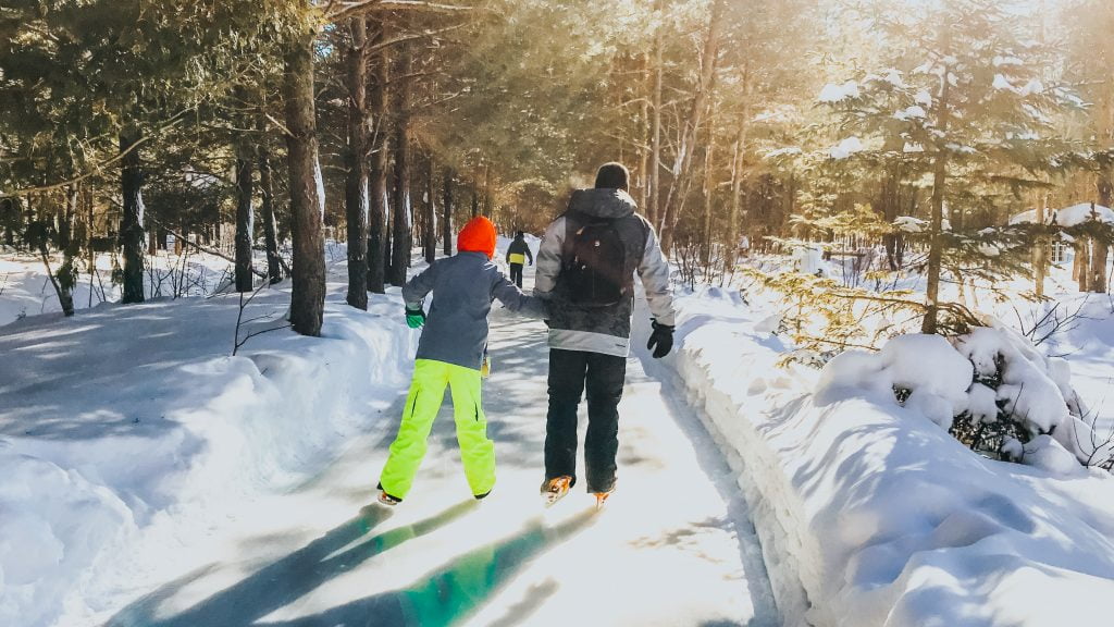 family skating through the forest in Quebec