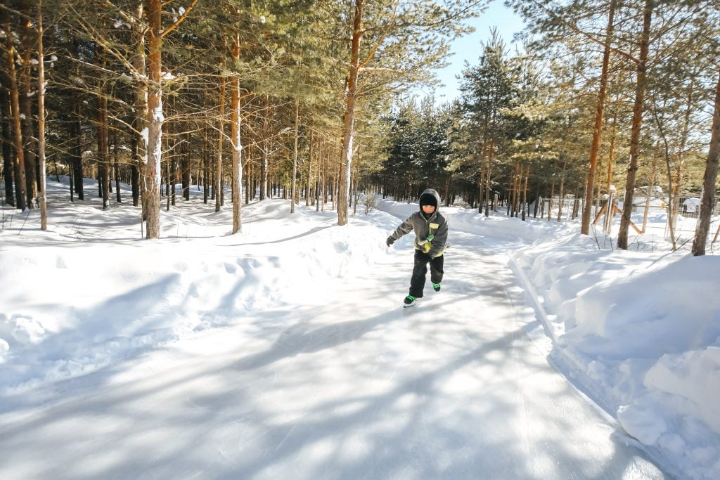 young child skating through the forest