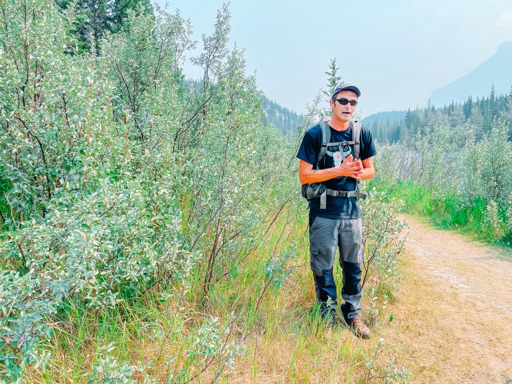 indigenous guide explaining local flora and fauna on a trail