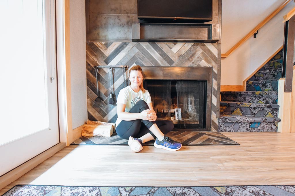 woman sitting in front of stone fireplace at tunnel mountain resort