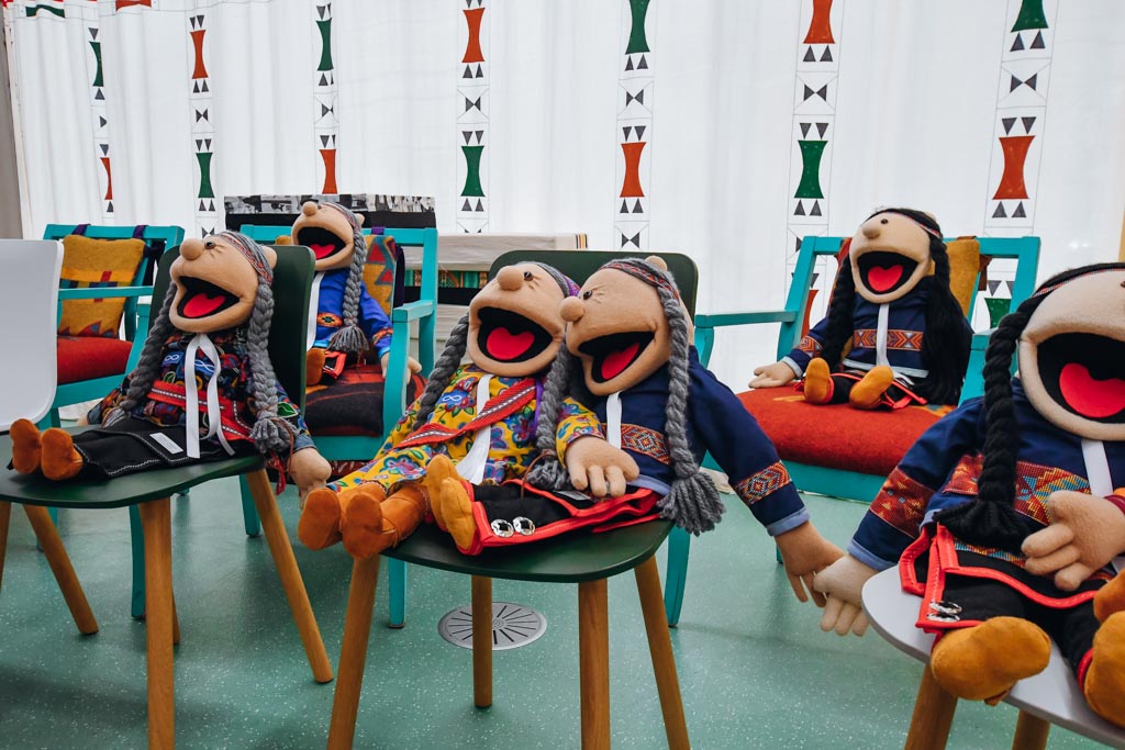 puppets sitting on chairs in a classroom