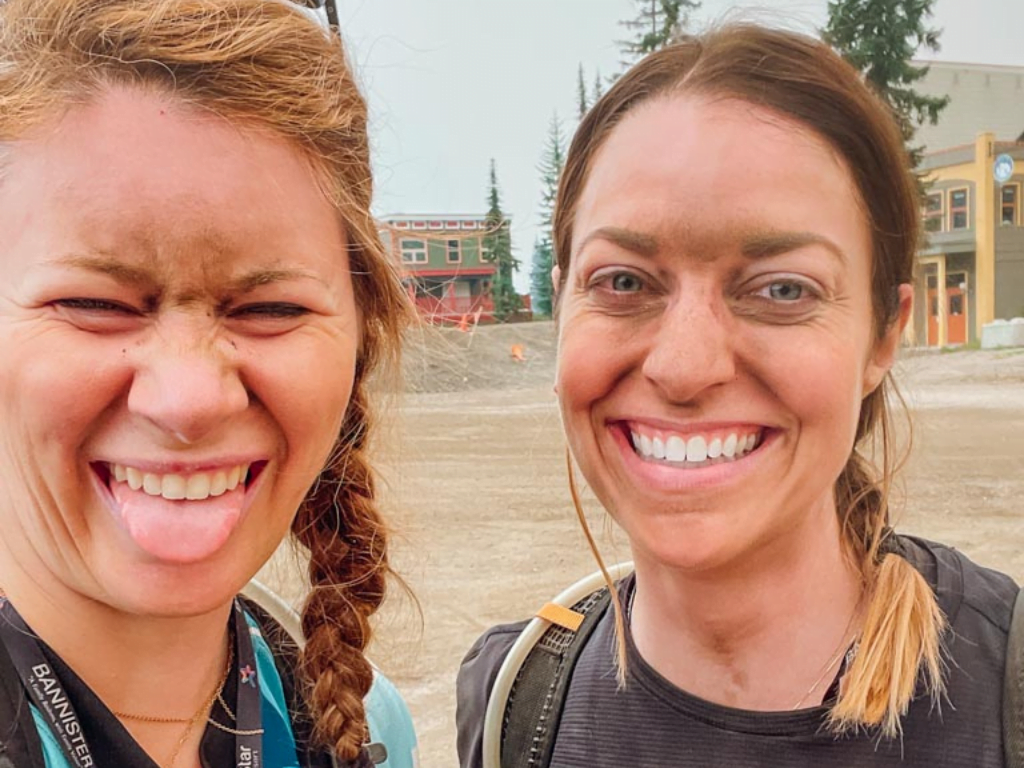 two woman covered in dust and dirt after their mountain biking course