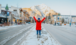 woman standing in the middle of the road in the town of banff
