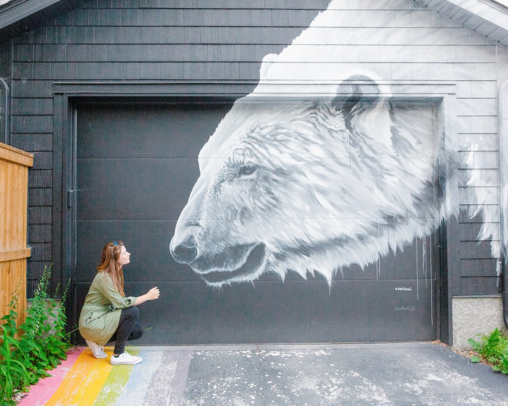 woman standing next to polar bear mural