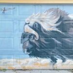 a mural of a bison running
