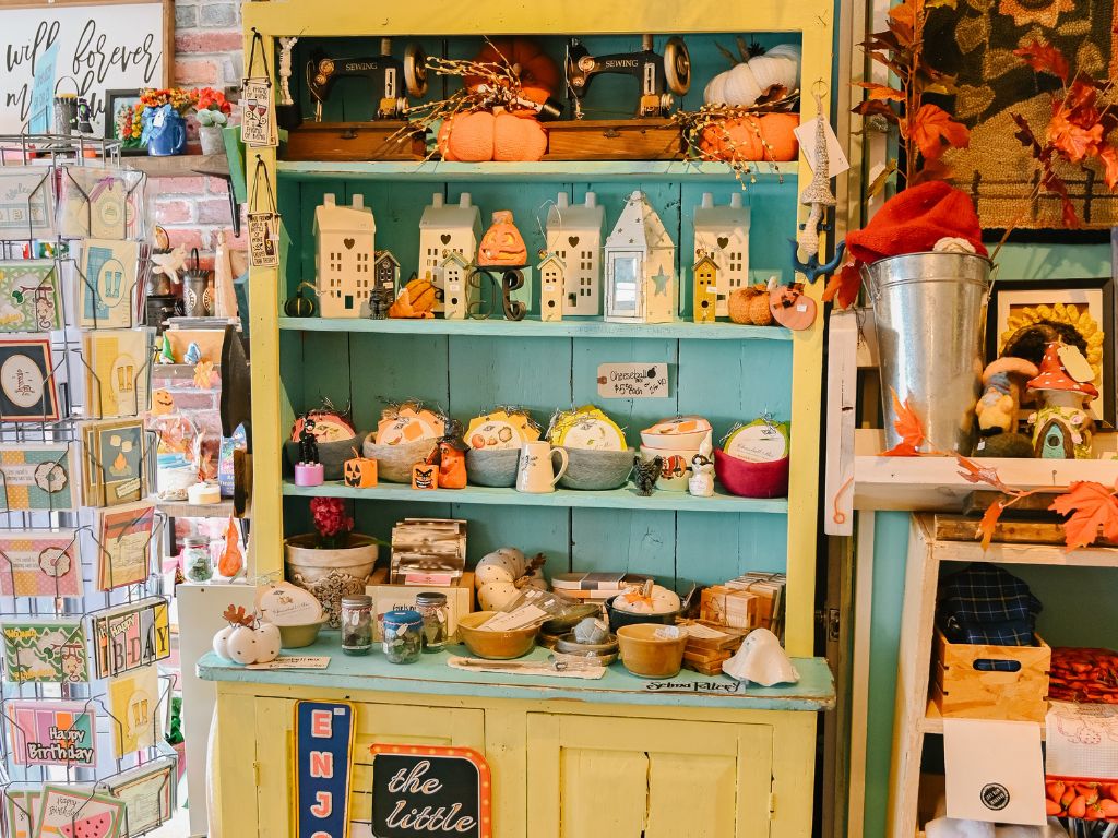 shelves full of pottery, cards and other fall related gifts inside the pumpkin village shop
