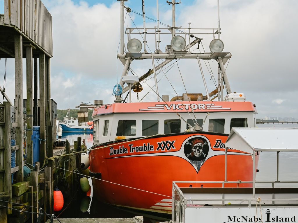 orange boat named double trouble docked at fisherman's cove nova scotia
