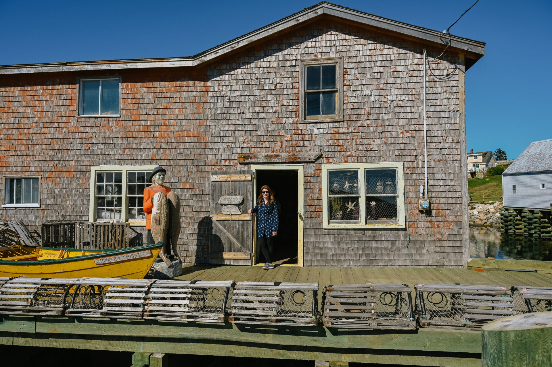 woman standing in the doorway of an old building on one of the many peggys cove tours
