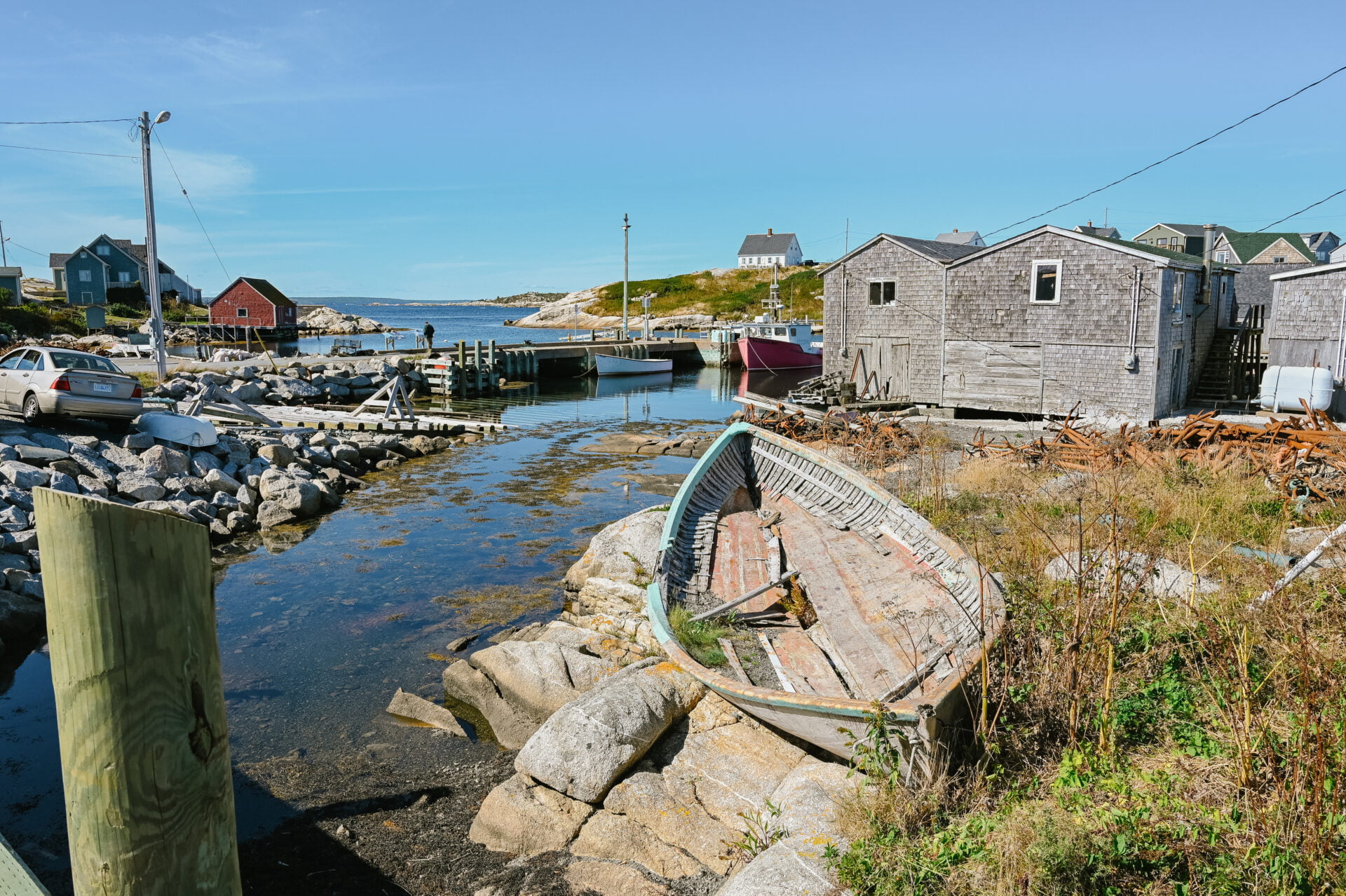 old rotting boat on the edge of the water in the town of peggys cove