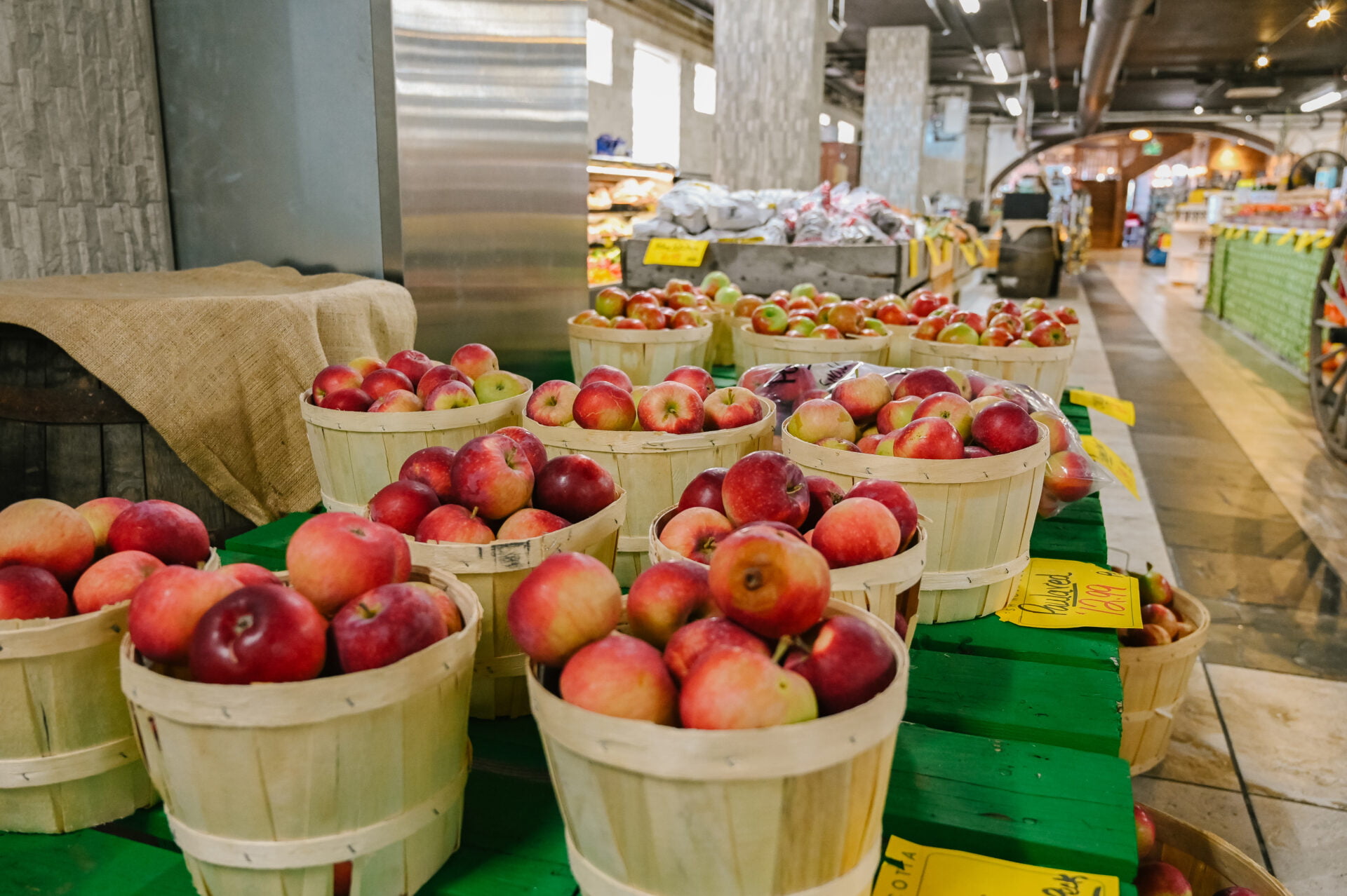 apples neatly stacked in wooden baskets and on display inside the bedford basin farmers market
