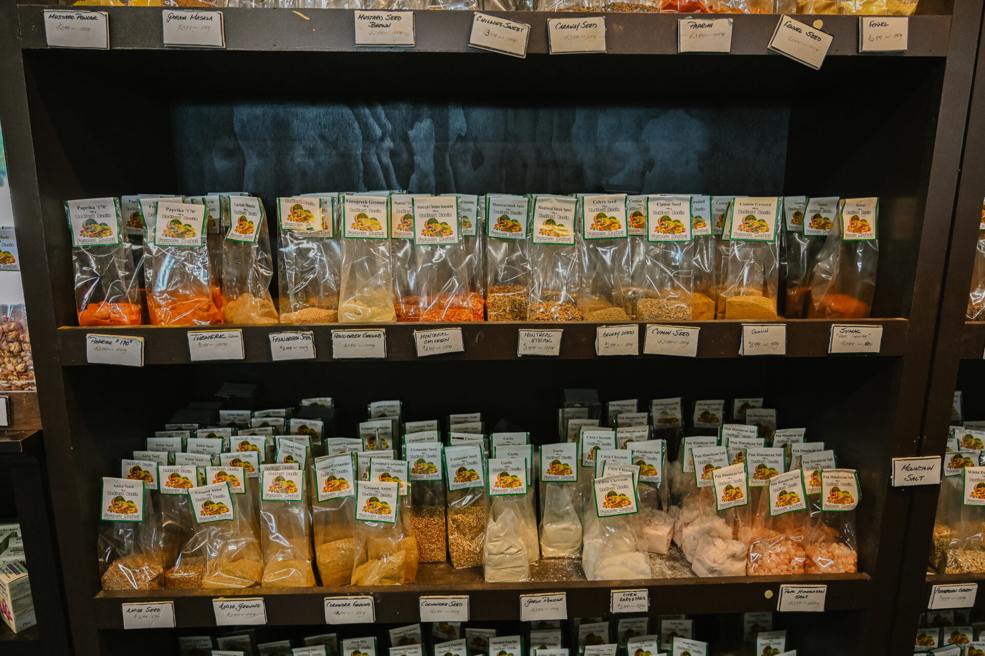 a selection of spices in bags lined up on a shelf inside the bedford basin farmers market