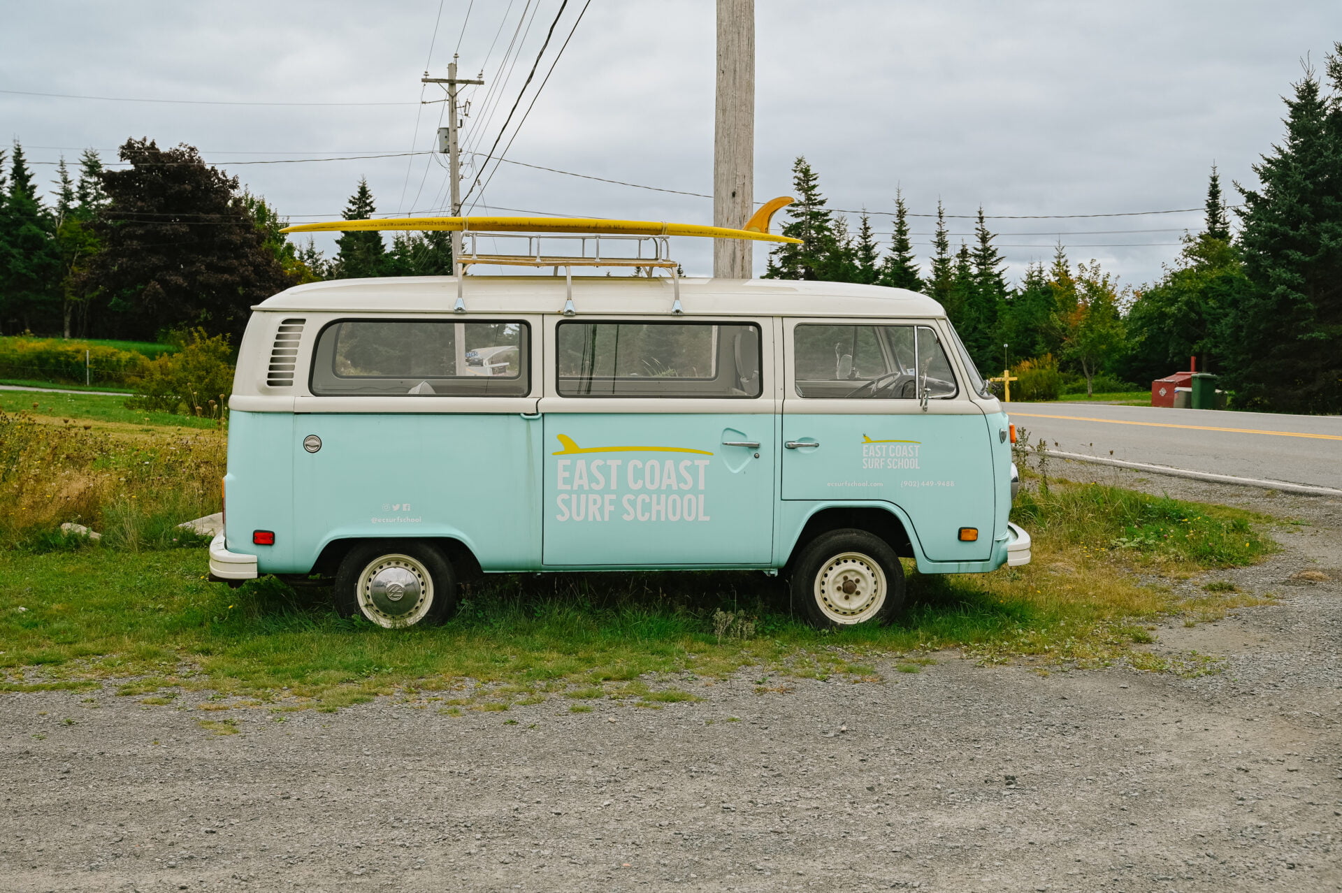 teal VW van with surf school logo on side sitting outside the lawrencetown surf shop