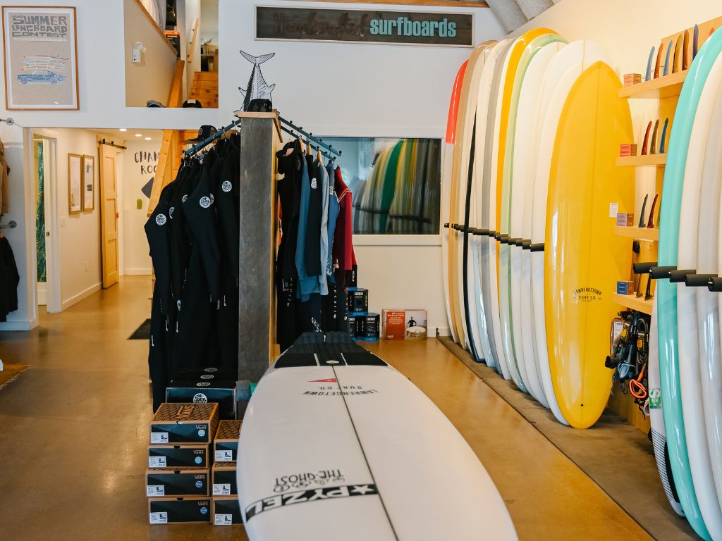 inside view of the lawrencetown surf shop where surf boards are lined up against the wall and wet suits are hanging