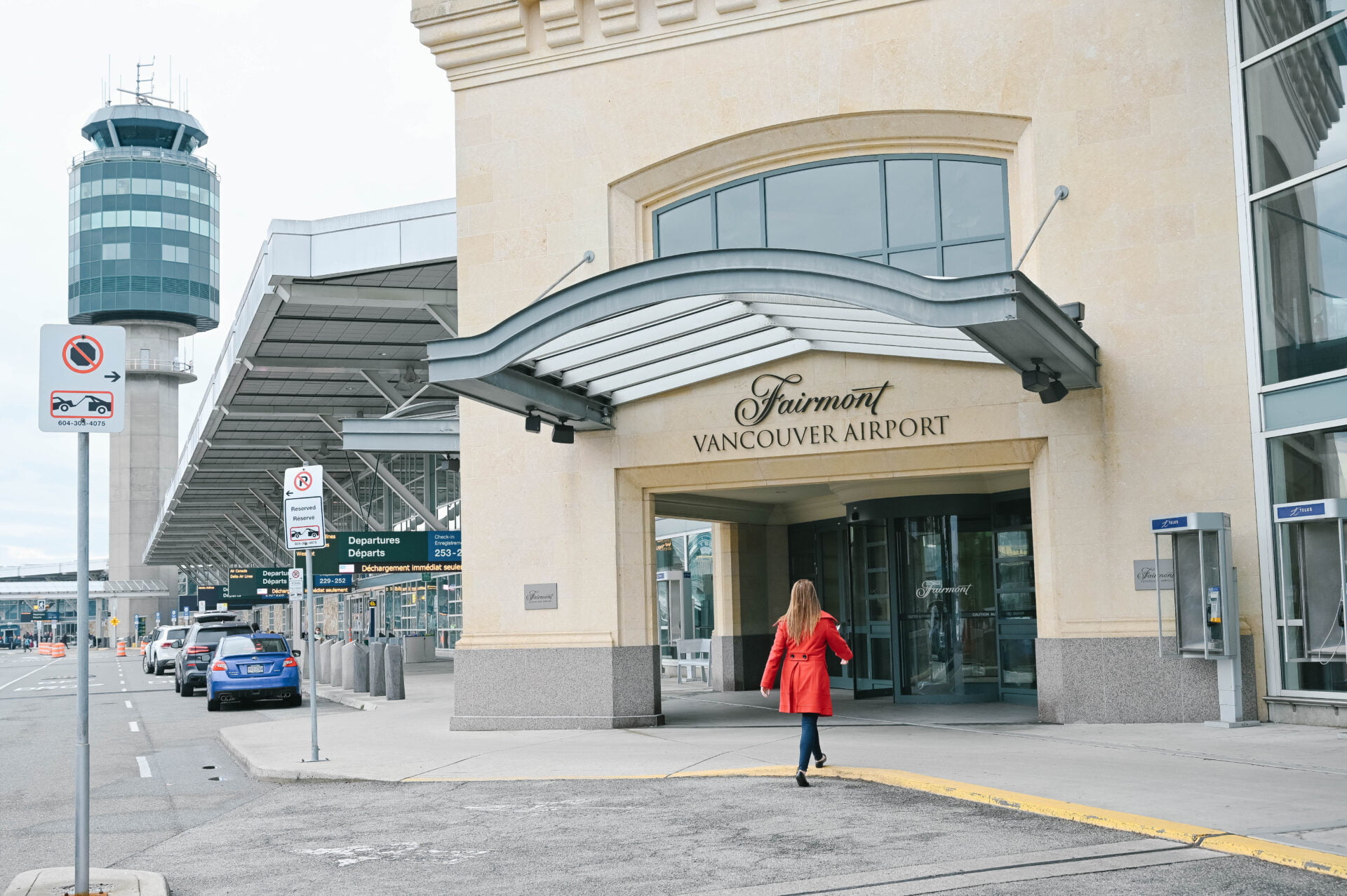 woman in red coat entering the fairmont vancouver airport hotel