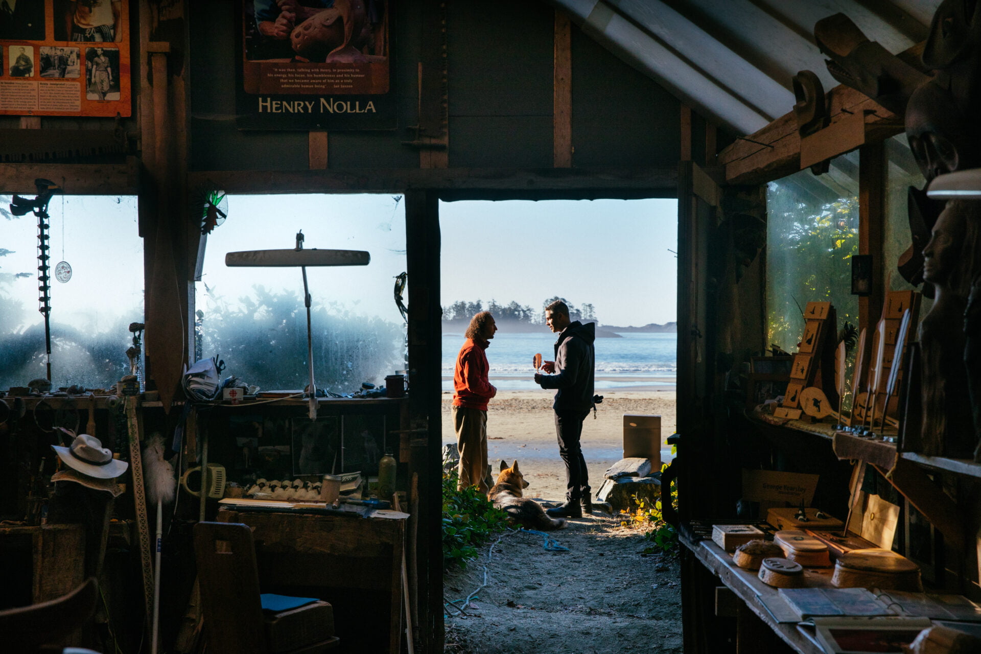 an artist speaks with someone outside an art studio on the beach at the wickanninish inn