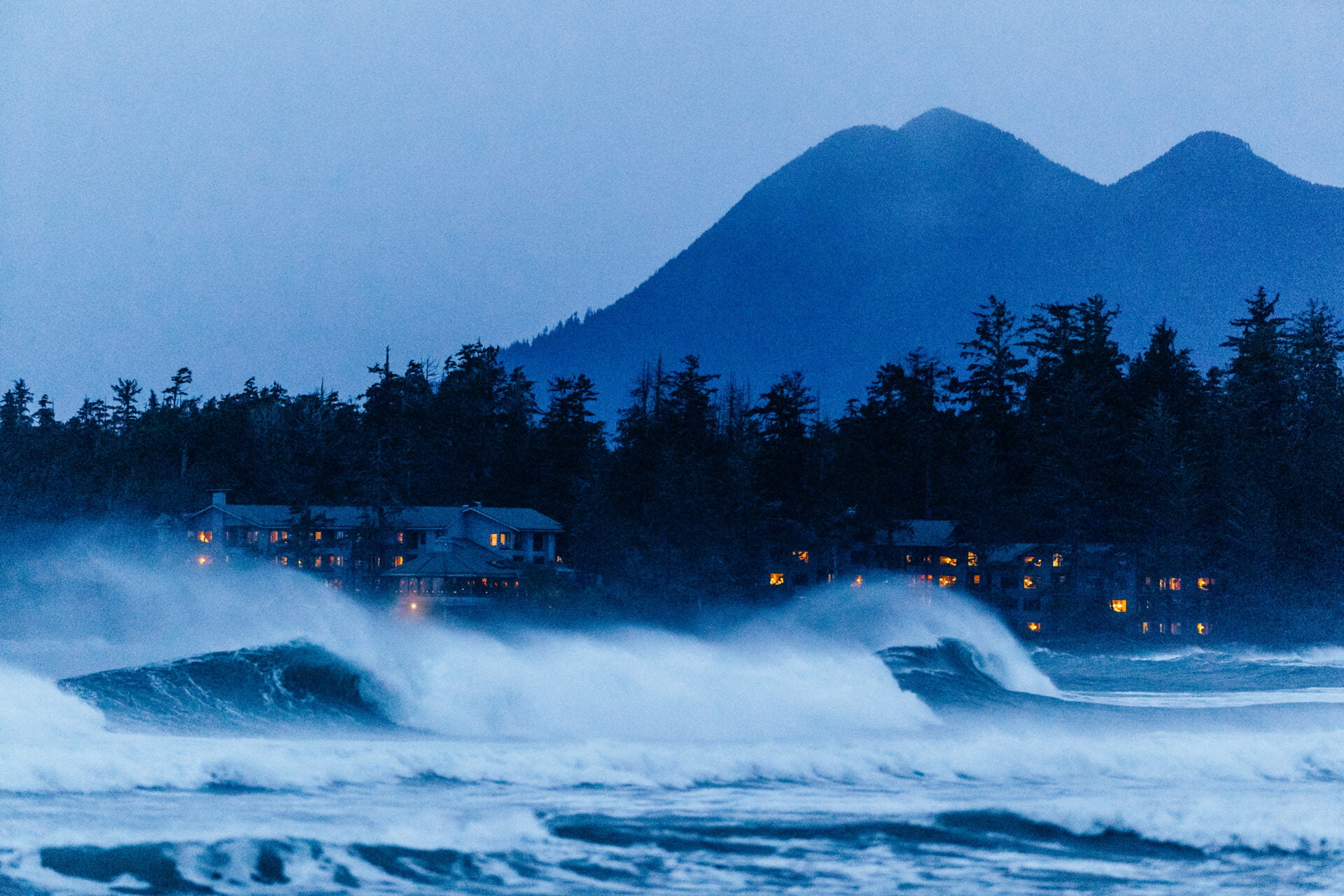 dark and moody photo of the best storm watching hotel in tofino taken from the ocean with large waves crashing