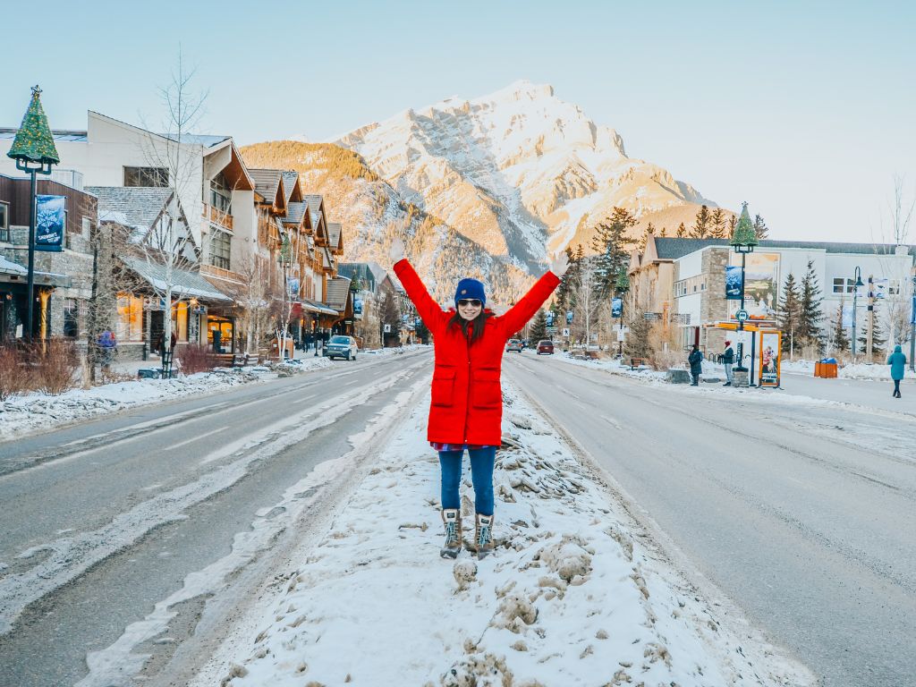 is blogging worth it? jami stands in the middle of the town of banff, a snow covered mountain is behind her in the distance