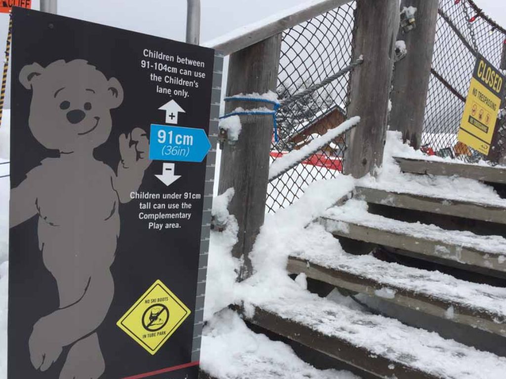 sign indicating the heights of kids and the height rules at the whistler tube park