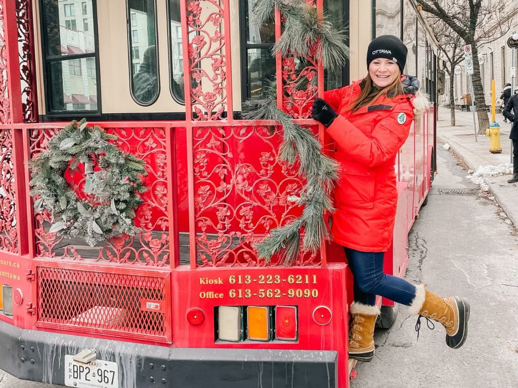 what to do in Ottawa in November - woman hanging off the side of an ottawa trolly tour bus