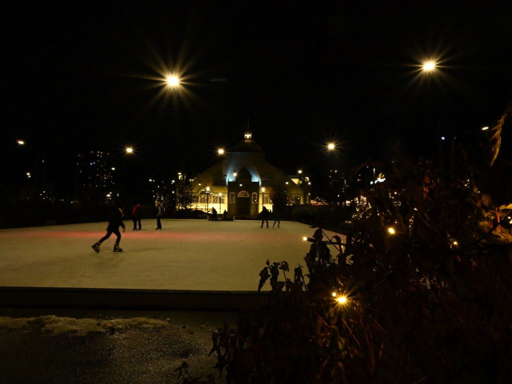 people skating on the outdoor rink that is beside the ottawa christmas market