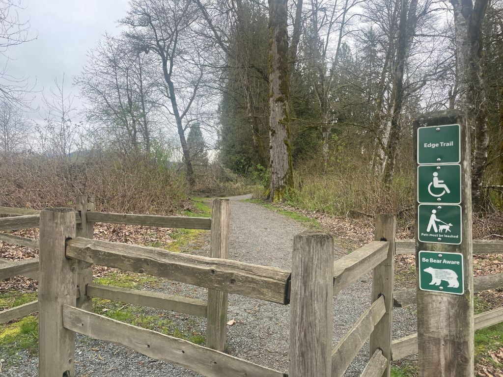 wooden fence and signage post on the edge trail in langley