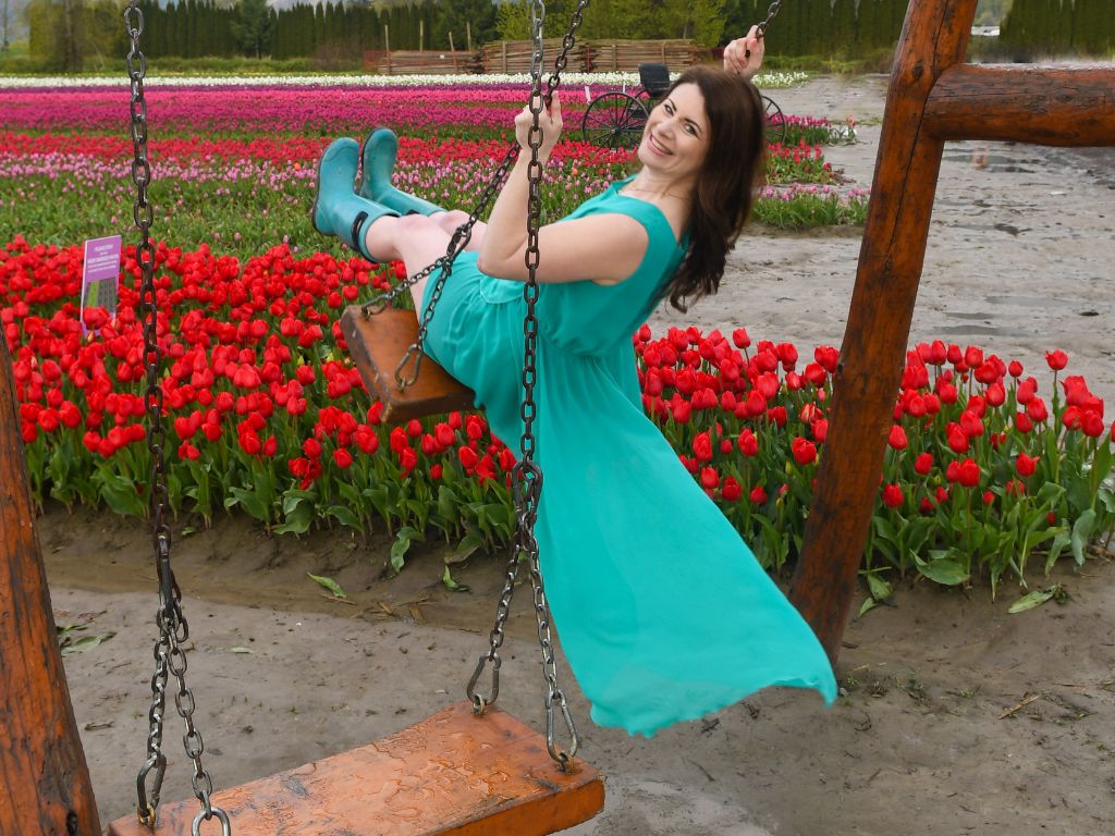 woman on a swing in the middle of a tulip field