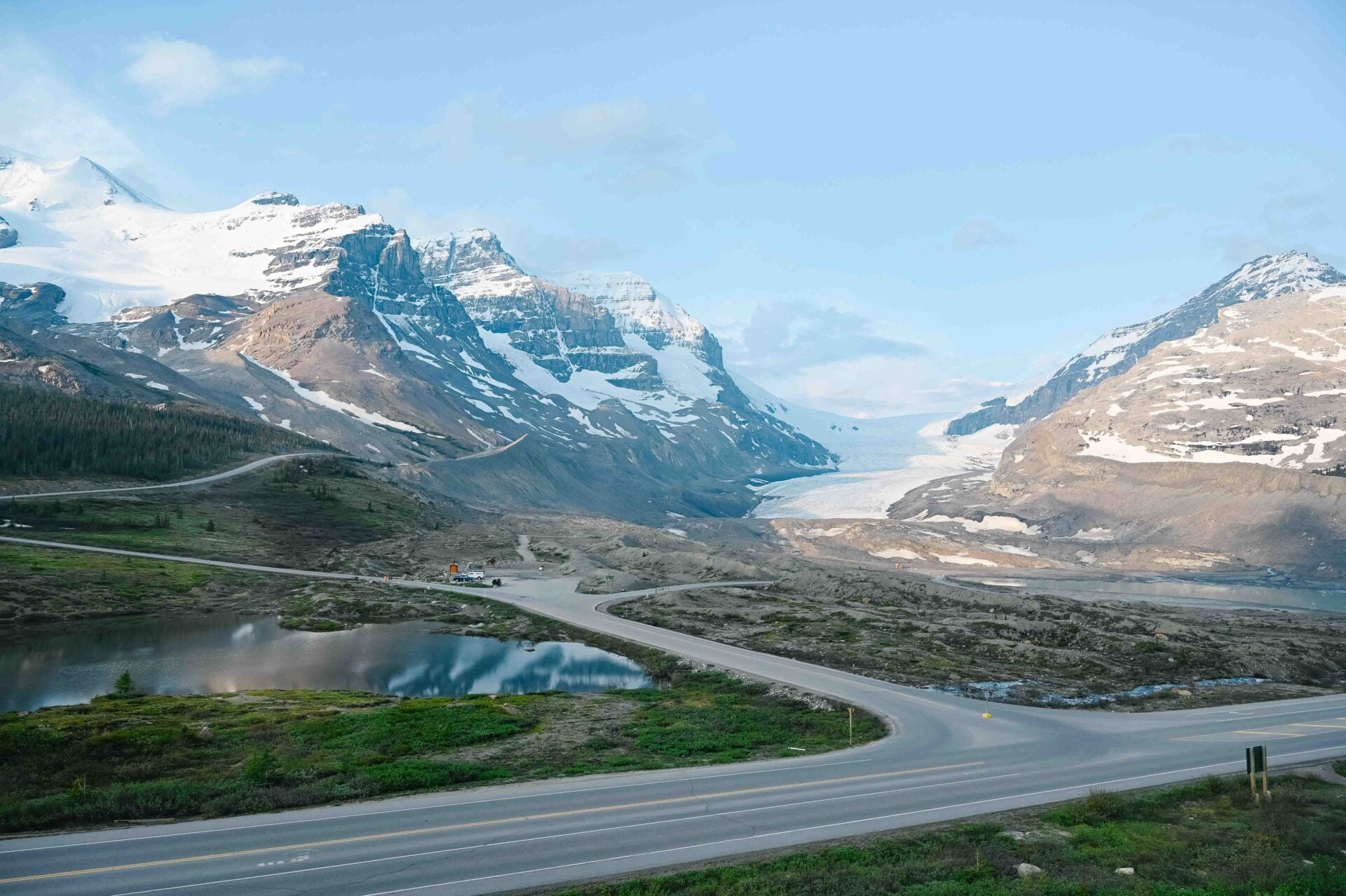 view of the athabasca glacier from across the highway with the mountains in the background