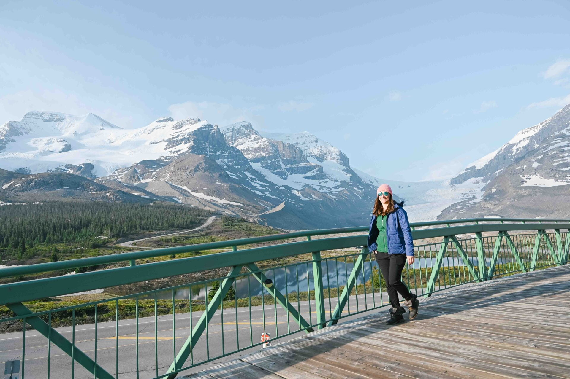 woman stands on a pedestrian bridge at the columbia icefield parkway
