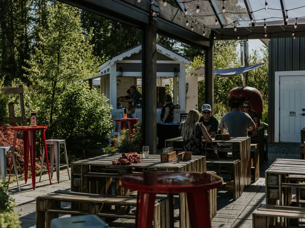 lots of people enjoying the sun while sitting on the patio at the fraser valley cider company, home to one of the best patios langley