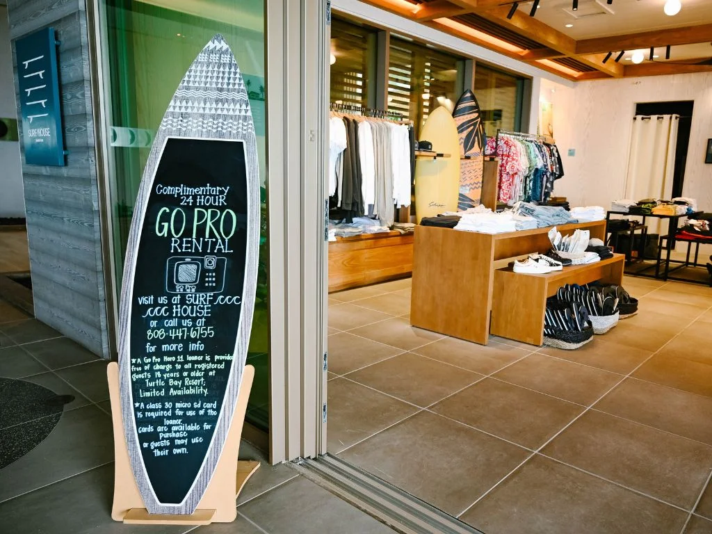 sign outside of the shop at turtle bay resort that advertises the complimentary gopro camera rentals they offer